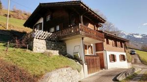 een huis met een balkon aan de zijkant bij Ferienhaus Stutz Hausteil links in Küblis