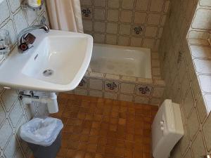 een badkamer met een wastafel, een toilet en een bad bij Ferienhaus Stutz Hausteil links in Küblis