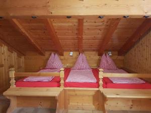 two beds in a sauna with red cushions at Ferienhaus Stutz Hausteil links in Küblis