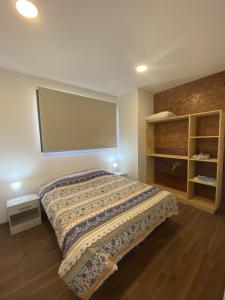a bedroom with a bed and a large screen at Patagonialiv in San Carlos de Bariloche