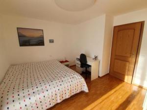 Schlafzimmer mit einem Bett, einem Schreibtisch und einer Tür in der Unterkunft Casa Ghiggi - Zweizimmerwohnung "Ticino" in Brissago