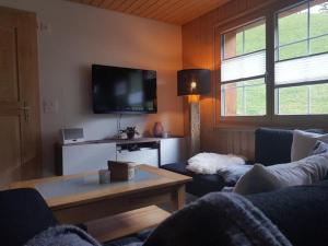 a living room with a couch and a tv at Ferien im Gugger - Wohnung Stockberg in Nesslau