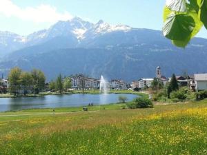 a lake with a fountain and a mountain in the background at Seeblick Fraissen in Laax