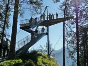 a group of people on a suspension bridge in the trees at Seeblick Fraissen in Laax