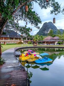 a group of boats parked on the water in front of a building at Bor Saen Pool Villa in Bor Saen