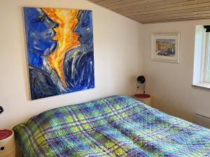 ジルレジェにある4 person holiday home in Gillelejeのベッドルーム1室(ベッド1台付)が備わります。壁には絵画が飾られています。