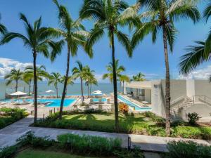 a resort with a swimming pool and palm trees at Beachfront & free daily breakfast & 600MB 7010 Wifi by Moikkarentals in Puerto Vallarta