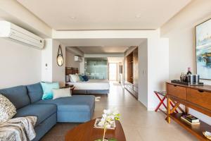 a living room with a blue couch and a bed at Beachfront & free daily breakfast & 600MB 7010 Wifi by Moikkarentals in Puerto Vallarta