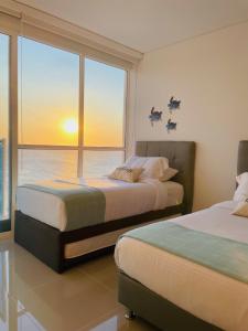 two beds in a room with a view of the ocean at APARTAMENTO CON VISTA AL MAR, RESERVA Del MAR 1637 in Gaira