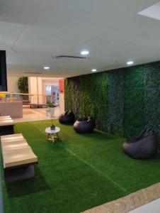 a room with a green wall with benches and grass at Embaixador Hotel e Centro de Eventos - by Fast10 Hotéis in Porto Alegre