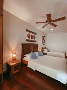 a bedroom with two beds and a ceiling fan at Corto del Mar Hotel in Coron
