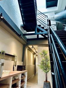 a room with a staircase and a tree in it at Armenian Guest House by LOLZ for 22pax in George Town