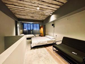 a bedroom with two beds and a couch in it at Armenian Guest House by LOLZ for 22pax in George Town