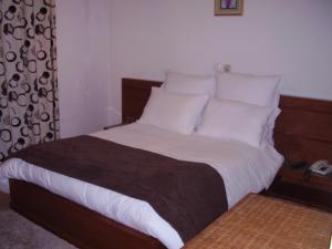a bedroom with a large bed with white sheets and pillows at Casa Morgado in Almeida