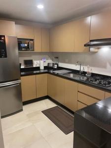 a kitchen with a sink and a stove top oven at Departamento Céntrico y Moderno en Cancún. in Cancún