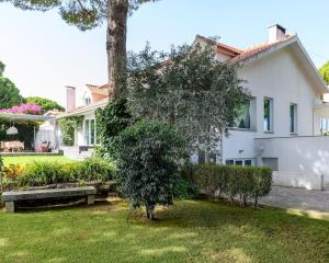 ein weißes Haus mit einem Baum im Hof in der Unterkunft VILLA MONZA CASCAIS in Cascais