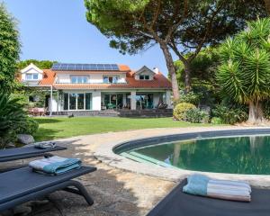 ein Haus mit einem Swimmingpool vor dem Haus in der Unterkunft VILLA MONZA CASCAIS in Cascais