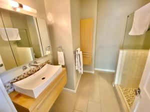 a bathroom with a white sink and a shower at Modern 6 bedroom retreat, stunning lake views, close to village! in Lake Arrowhead +20 photos