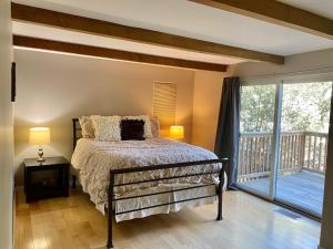 a bedroom with a bed and a balcony at Modern 6 bedroom retreat, stunning lake views, close to village! in Lake Arrowhead
