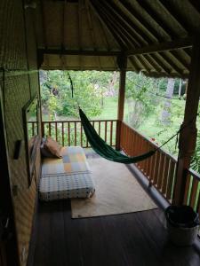 a hammock on the porch of a cabin at Tangga Bungalows in Gili Air
