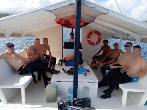 un groupe d'hommes assis sur un bateau dans l'établissement Jalyn's Resort Sabang, à Puerto Galera