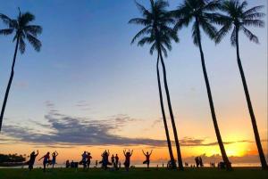 eine Gruppe von Leuten, die Yoga am Strand mit Palmen machen in der Unterkunft Modern Studio - Heart of Waikiki with Parking! in Honolulu