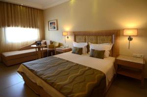 a hotel room with a large bed and a couch at Danai Hotel & Spa in Olympic Beach