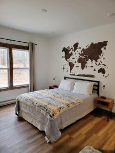 1 dormitorio con 1 cama con mapa en la pared en Silver Lake & Dunes Dream Home, en Mears