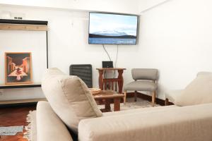 a living room with two couches and a flat screen tv at CORTEZ CASA in Ushuaia
