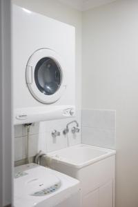 a bathroom with a sink and a washing machine at Middleton Beach by the BnB Collection in Albany