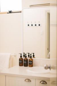a bathroom with three bottles of soap on a sink at Middleton Beach by the BnB Collection in Albany