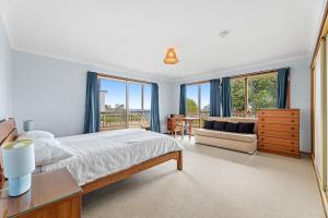 una camera da letto con un letto, un divano e finestre di 54 Noble Parade a Dalmeny