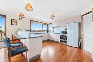 una cucina con mobili bianchi e un piano di lavoro di 54 Noble Parade a Dalmeny