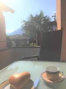 un tavolo con un panino e una tazza sopra di Casa alle Vigne Apt 101 ad Ascona