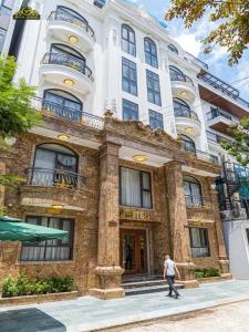 une personne marchant devant un bâtiment dans l'établissement VP Hotel Luxury, à Hanoï