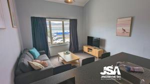a living room with a couch and a television at Razorback 14 in Jindabyne