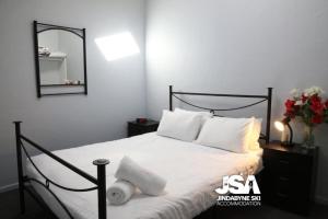a bedroom with a bed with white sheets and a mirror at Razorback 14 in Jindabyne