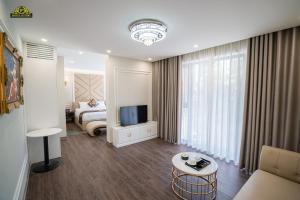 ein Wohnzimmer mit einem Bett und einem TV in einem Zimmer in der Unterkunft VP Hotel Luxury in Hanoi