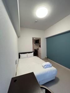 een kleine kamer met een bed en een krijtbord bij BiBi Hotel 泊ポート in Naha