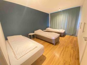 een kamer met 2 bedden in een kamer met houten vloeren bij Spacious 3 bedroom apartment,close to centrum. in Reykjavík