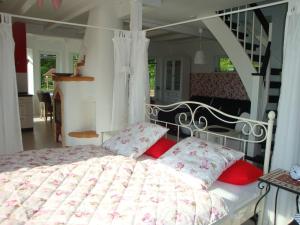 a bedroom with a white bed with red pillows at Haus Dornröschen in Rakow