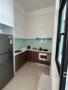uma cozinha com armários brancos, um lavatório e um frigorífico em Simple Muji HomeStay@ Lavile em Kuala Lumpur