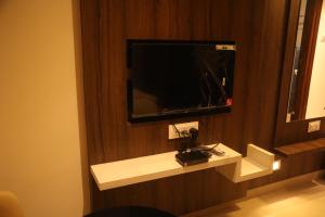 a bathroom with a tv on a wall with a white counter at Royal Indraprastha The Hotel in Bengaluru