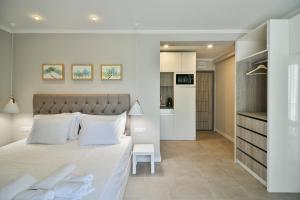 Sea lounge في مدينة فارنا: غرفة نوم بسرير ابيض كبير ومطبخ