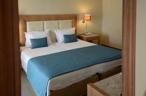 a bedroom with a large bed with a blue blanket at Danai Hotel & Spa in Olympic Beach