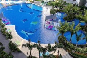 an overhead view of a large swimming pool with palm trees at Atlantis Residence Batik Travel in Tranquerah +4 photos