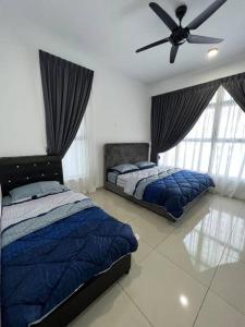 Tranquerah的住宿－Atlantis Residence Batik Travel，一间卧室配有两张床和吊扇
