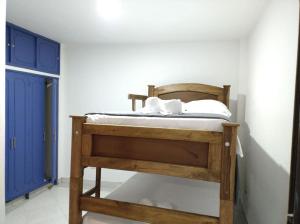 Litera de madera en habitación con puerta azul en Apartamento céntrico, cómodo y completamente privado en Cali, en Cali