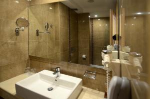 a bathroom with a sink and a mirror at Danai Hotel & Spa in Olympic Beach