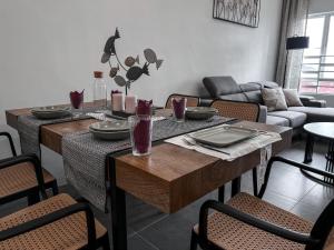 Ins2 Langkawi Apartment Kuah في كواه: غرفة معيشة مع طاولة وأريكة